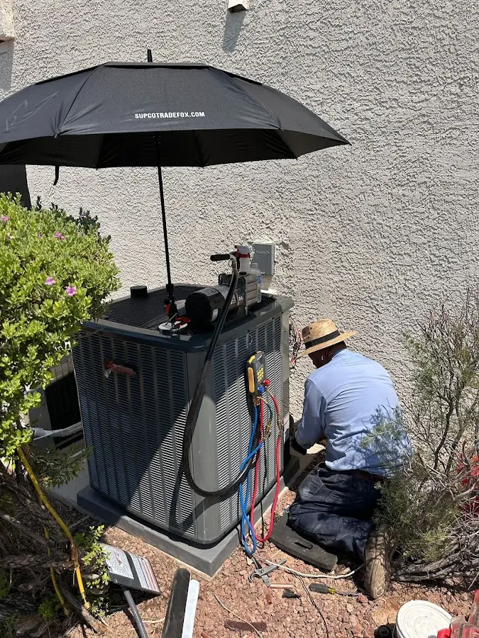 HVAC technician performing outdoor AC maintenance in Waterboro