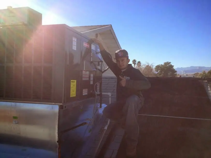 HVAC technician performing AC Tune-Up on a rooftop unit in Waterboro
